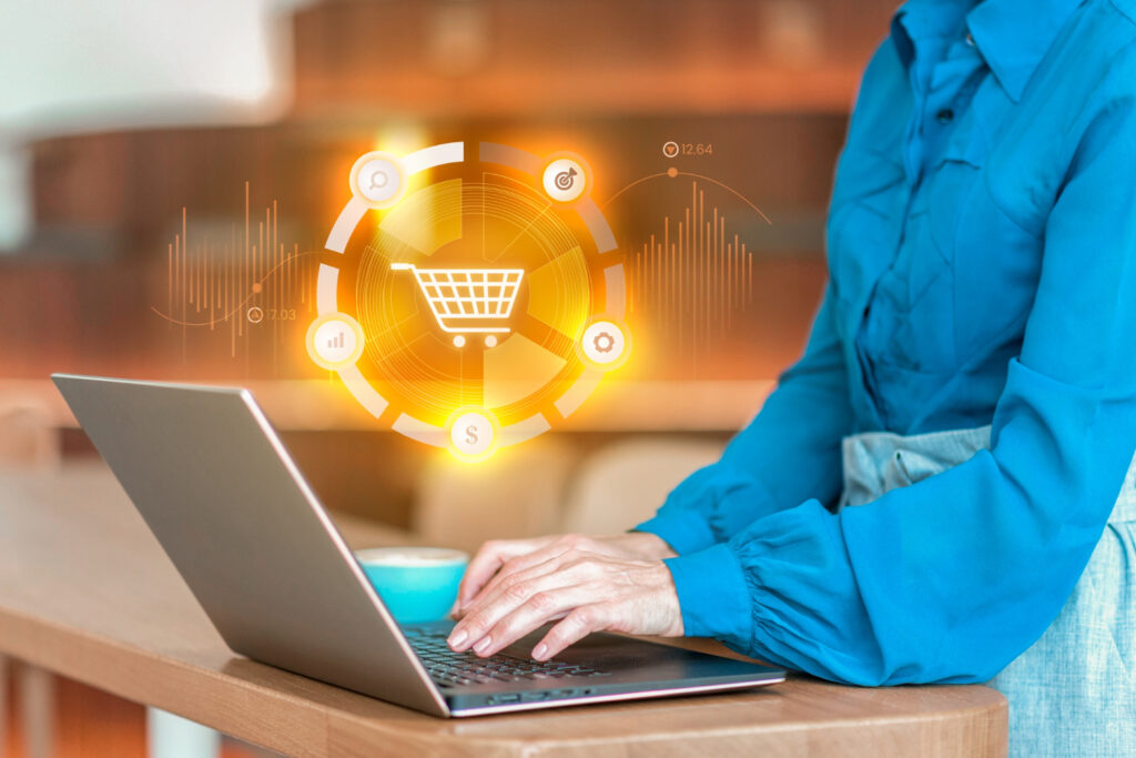 Woman shopping online on laptop with cart icon displayed in Web& app Development.