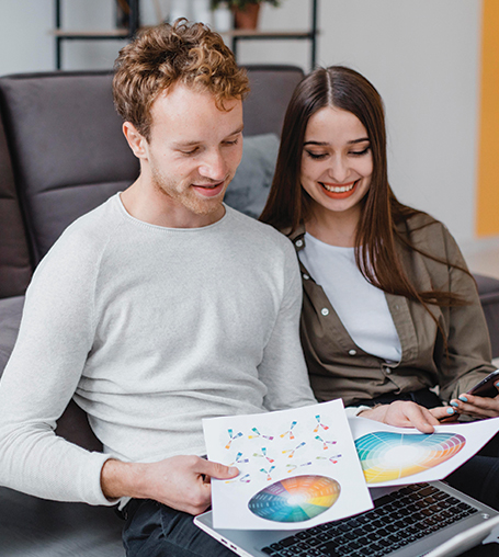 A man and a woman sitting on a couch an Advertising.