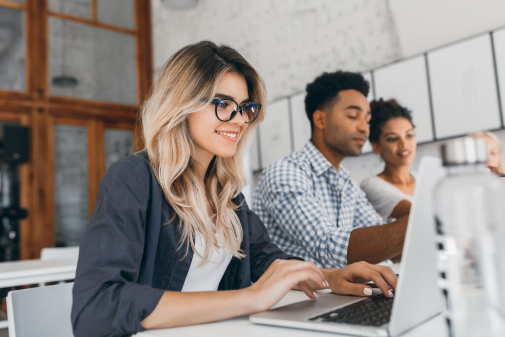 A woman typing on a laptop with a shield on the screen and Affiliate marketer.